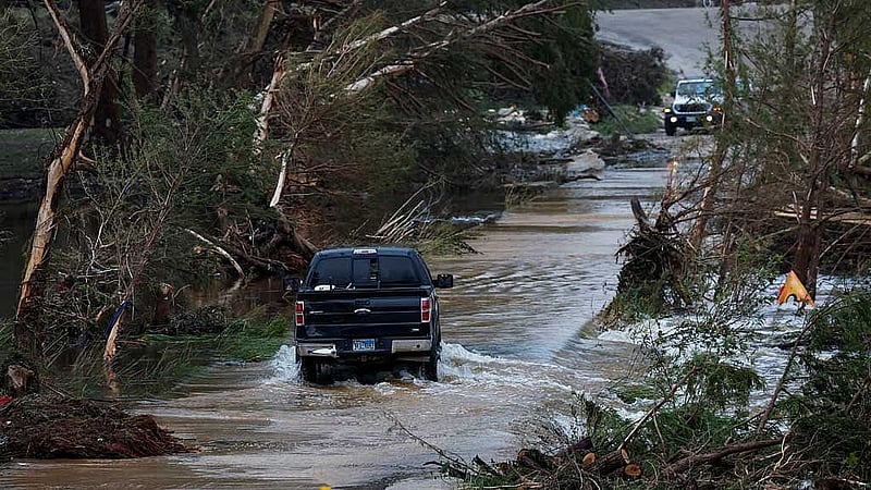 A vehicle rides through a flooded road, following flash flooding, in Hunt, Texas, US Jul 6, 2025. REUTERS   texas-flood-070725-01.JPG