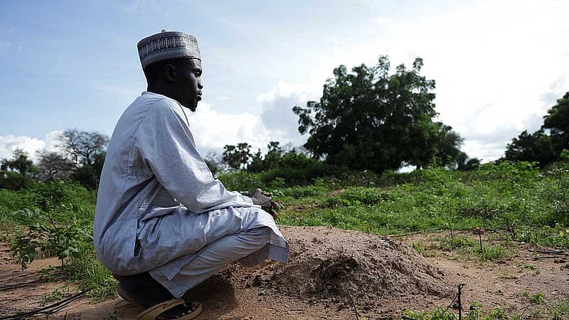 Alhadji Madou Goni kneels near the grave of Mohamat, his nine-month-old son, who died of complications from malaria, in Bogo, Cameroon Sept 4, 2025. REUTERS/Desire Danga Essigue