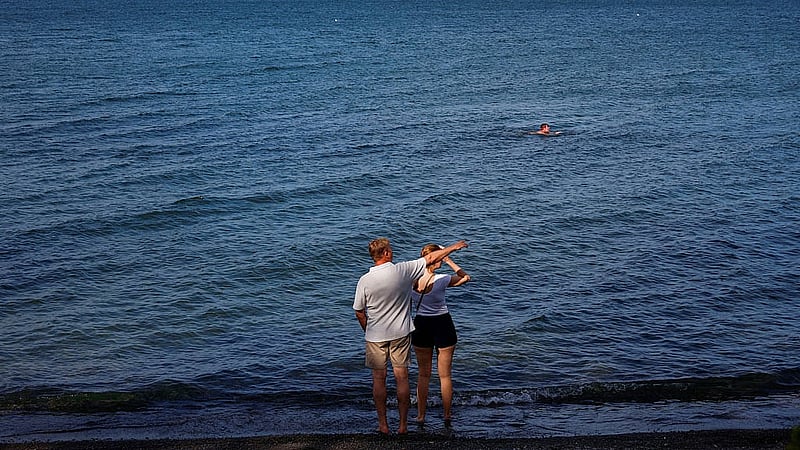 People stand along the shore of Lake Ontario after US President Donald Trump signed an executive order renaming Lake Ontario as Lake America, a change he said would take effect immediately, in Hamilton, Ontario, Canada, Aug 27, 2026. REUTERS/Carlos Osorio