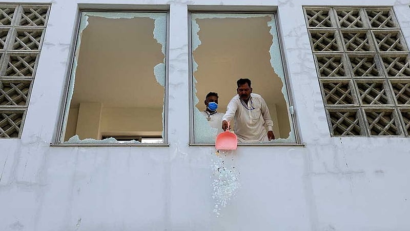 A worker removes broken pieces of a glass window after a fire broke out at the Pakistan Institute of Medical Sciences (PIMS) hospital in Islamabad, Pakistan, Aug 26, 2026. REUTERS/Akhtar Soomro