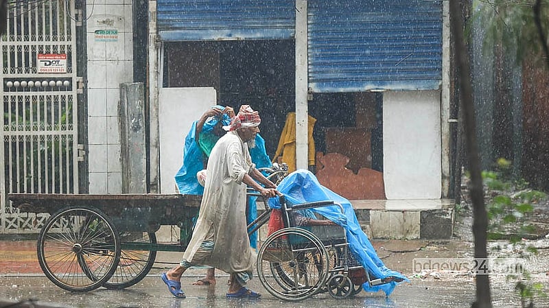 Daily labourers and low-income people struggle in Monday's midday rain in Dhaka's Rampura area. Photo: Shamsul Haque Ripon