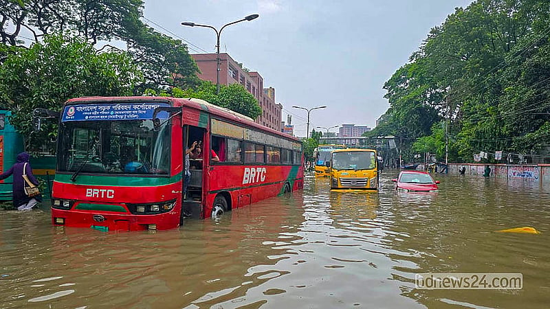 Vehicles are left stranded in waist-deep water on the flooded Arambagh road following heavy rain on Sunday, Jul 12, 2026.  Photo: Abdullah Al Momin