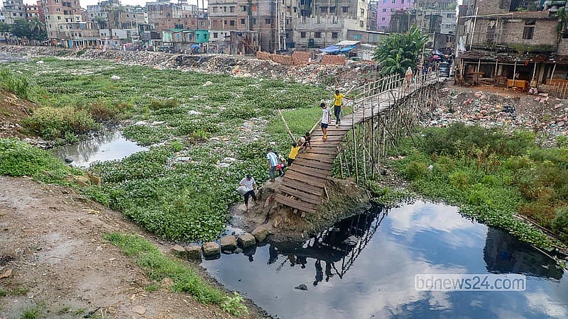 People cross a broken bridge on the Adi Buriganga channel in the Rasulpur area of Dhaka's Kamrangirchar. Photo: Abdullah Al Momin