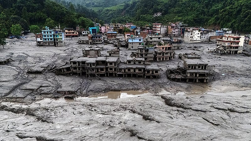 A drone view shows damaged buildings and houses covered in mud next to the Likhu River following deadly flash floods and mudslides, in Devighat, Nuwakot district, Nepal, Aug 30, 2026. REUTERS/Athit Perawongmetha