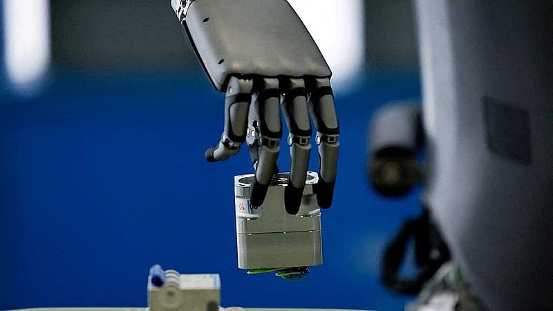 A UBTech humanoid robot, Walker S, picks up an object operated by a staff member, during a demonstration simulating a factory's assembly line, at the robotics exhibition centre Robot World, during an organised media tour to the Beijing Robotics Industrial Park, in Beijing Economic-Technological Development Area, also known as Beijing E-Town, in China May 16, 2025. REUTERS/Tingshu Wang To Match Special Report CHINA-TECH/ROBOT