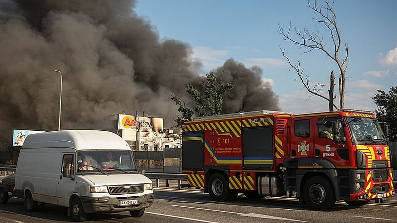 A firetruck and other vehicles pass by a warehouse hit by a Russian drone strike with a melted Avrora Multimarket sign, amid Russia's attack on Ukraine, in Kyiv region, Ukraine, Aug 31, 2026. REUTERS/Alina Smutko