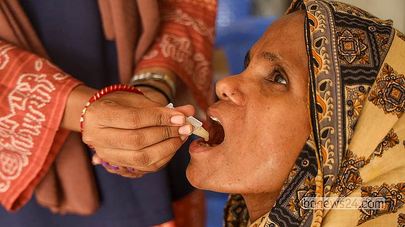 A health worker administers an oral cholera vaccine to a woman.  Photo: Shamsul Haque Ripon