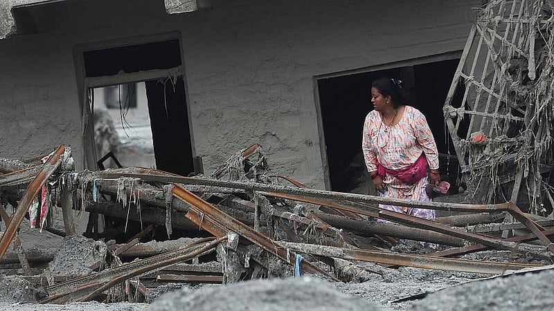 A woman inspects a damaged house after flash floods and a mudslide, at Devighat, Nuwakot district, Nepal, Aug 31, 2026. REUTERS/Francis Mascarenhas