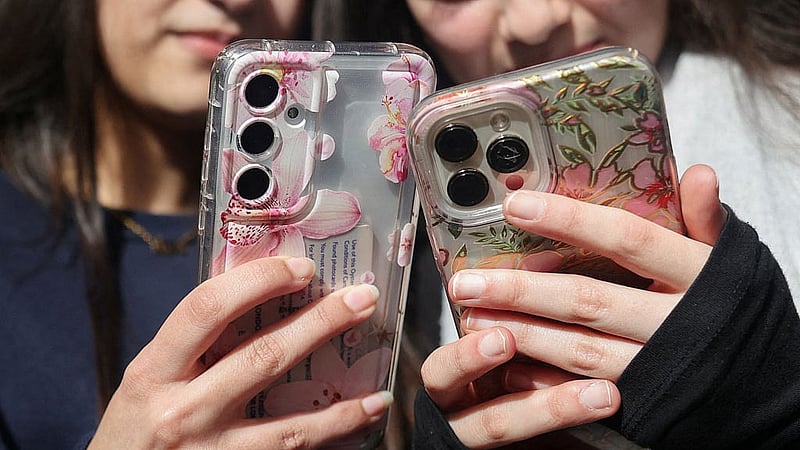 Students from Ricards Lodge High School in Wimbledon pose holding their mobile phones in London, Britain. REUTERS