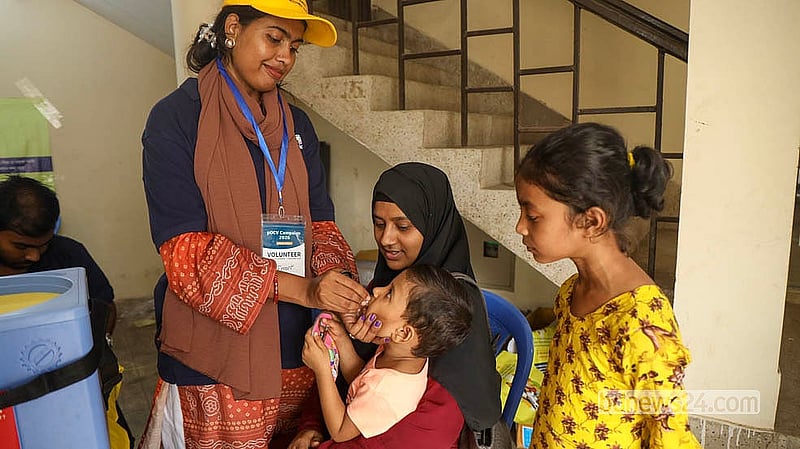 A health worker gives cholera vaccine to a child cradled in her mother’s arms.  Photo: Shamsul Haque Ripon