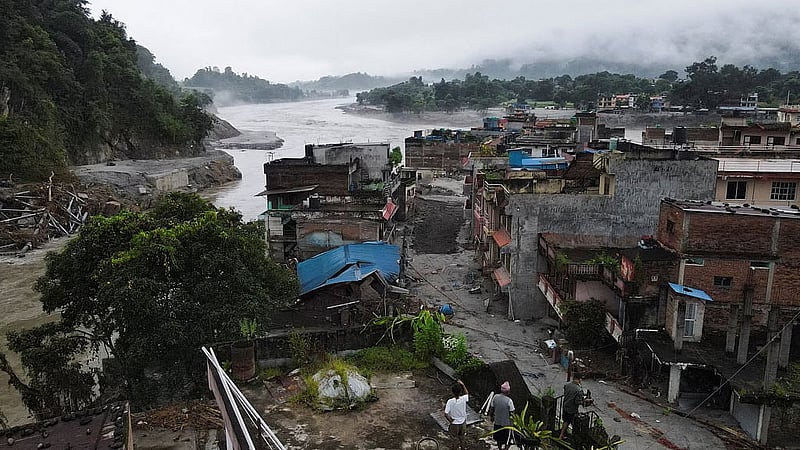 Drone view of people inspecting a damaged house after the deadly flash floods and mudslide, at Devighat, Nuwakot district, Nepal, Aug 31, 2026. REUTERS/Francis Mascarenhas