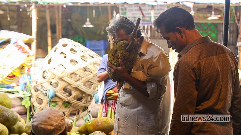 Buyers check the size, aroma and ripeness of jackfruits before purchasing them at Karwan Bazar.  Photo: Shamsul Haque Ripon