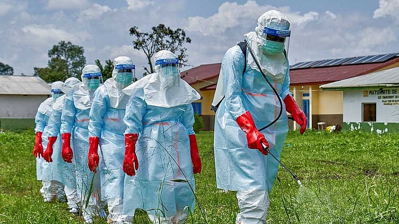 Red Cross workers walk in a formation as they disinfect Rwampara general hospital before handling the body of a person who died of Ebola, as aid agencies intensify efforts to contain a new Ebola outbreak involving the Bundibugyo strain, in Rwampara outside Bunia, Ituri province, Democratic Republic of Congo, May 21, 2026. REUTERS/Gradel Muyisa Mumbere/File Photo