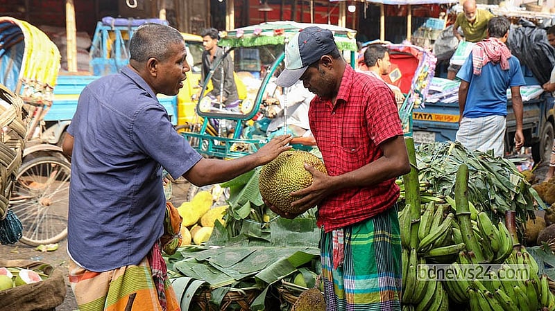 Buyers check the size, aroma and ripeness of jackfruits before purchasing them at Karwan Bazar.  Photo: Shamsul Haque Ripon
