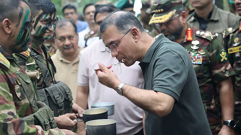 Prime Minister Tarique Rahman samples a field meal prepared by soldiers under simulated battlefield conditions during the Army's summer exercise in Babuganj. Photo: PMO