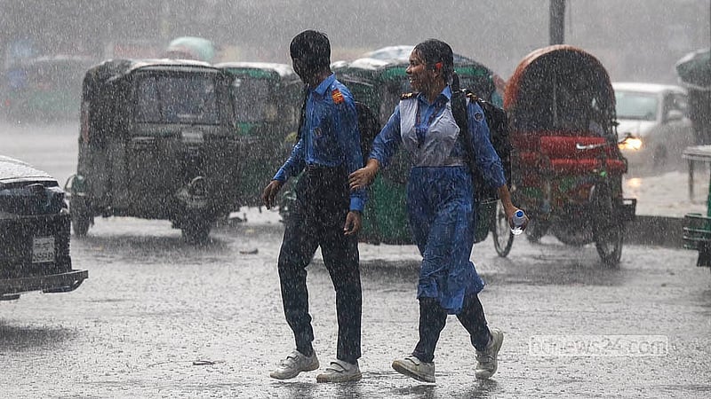 Unfazed by the rain and without umbrellas, two students make their way home with smiles on their faces in Dhaka University area on Saturday, Jun 13, 2026.  Photo: Shamsul Haque Ripon