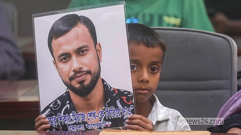 The child of Meraj Sheikh, an enforced disappearance victim from Mongla in Bagerhat, holds a photograph of his father at the National Press Club event on Saturday, Aug 29, 2026. Photo: Abdullah Al Momin