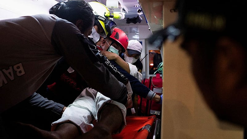 Rescuers move a passenger evacuated from the Virgo Transport 8 ship that sank while sailing from Surabaya in East Java to Banjarmasin in South Kalimantan, into an ambulance to be transported to a hospital, after they arrived at Trisakti port in Banjarmasin, South Kalimantan province, Indonesia, Sept 13, 2026. REUTERS/Stringer