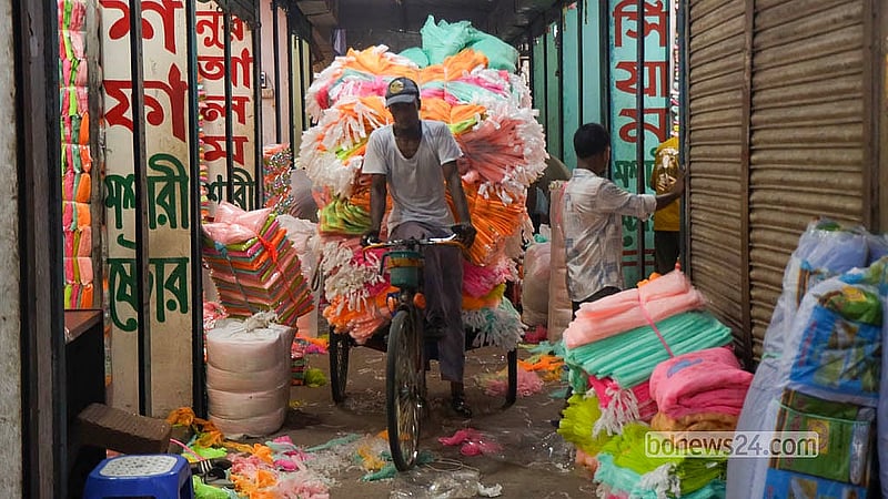 A transport worker carries sacks of mosquito nets from the Bhulta Gausia wholesale hub in Rupganj for distribution across the country.   Photo: Shamsul Haque Ripon