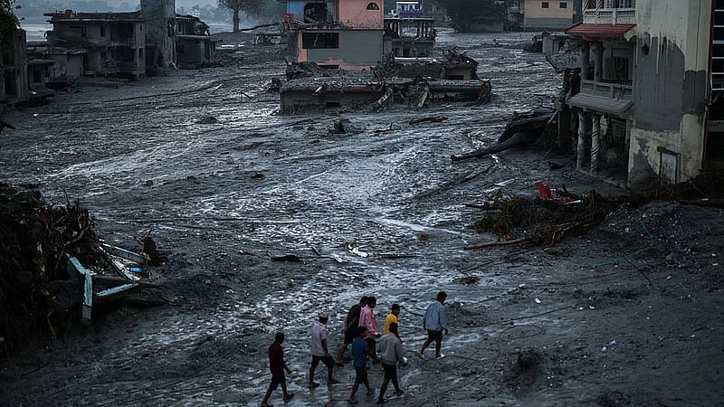 People walk next to damaged buildings, following the deadly flash floods and mudslides in Devighat, Nuwakot district, Nepal, Sept 3, 2026. REUTERS/Athit Perawongmetha