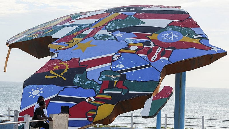 People stand beside a sculpture of the African continent, painted with the flags of African nations, at the Place du Souvenir Africain in Dakar, Senegal, Sept 3, 2026. REUTERS