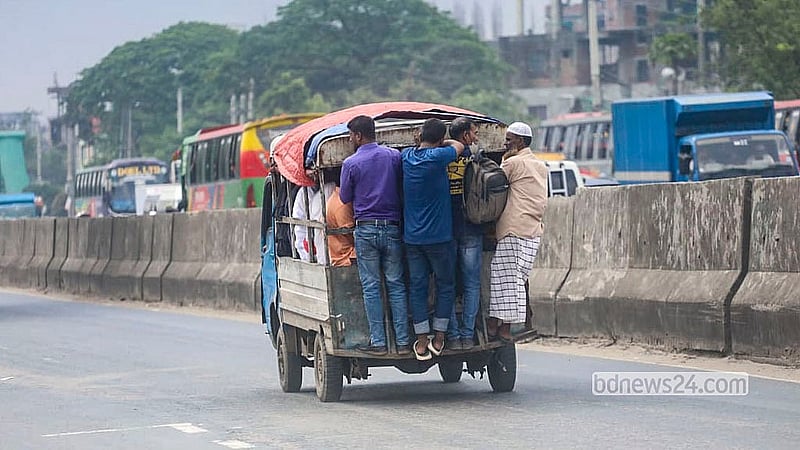 Low-income commuters hang from the back of a human haulier as they head to their destinations amid a shortage of public transport at Rayerbagh on the Dhaka-Chattogram Highway on Saturday, Sept 5, 2026.  Photo: Abdullah Al Momin