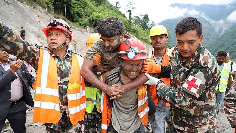 A man who survived is carried by members of a search and rescue team after they rescued alive two people who had been trapped inside a tunnel at the Trishuli-3A Hydropower Project following devastating floods and mudslides that struck the Bhotekoshi River in Rasuwa, Nepal, Sep 4, 2026. Photo: Reuters