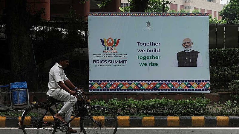 A man cycles past a hoarding featuring India's Prime Minister Narendra Modi ahead of the 18th BRICS Summit in New Delhi, India, Sept 11, 2026. REUTERS