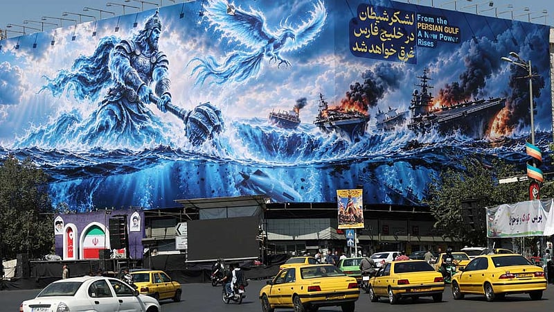 People drive past a billboard about the Strait of Hormuz, on a building in Tehran, Iran, Sept 16, 2026.
