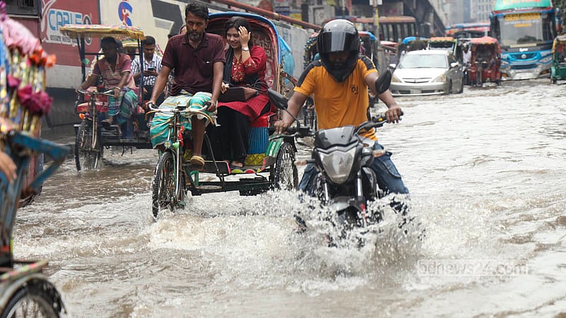 The main road in Shantinagar is submerged as rickshaws and motorcycles carrying passengers splash through the floodwater. Shamsul Haque Ripon