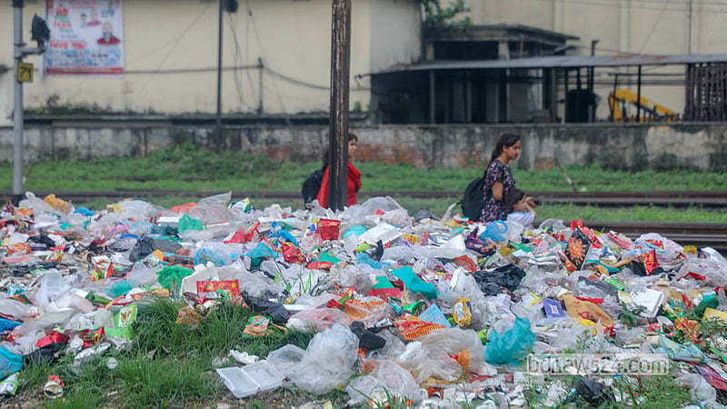 Passengers walk past piles of scattered garbage alongside the tracks at Dhaka’s Kamalapur Railway Station. Photo: Abdullah Al Momin