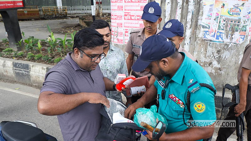 A police officer searches a motorcyclist’s bag at a checkpoint near the High Court intersection in Dhaka on Friday, Sept 25, 2026. Photo: Shamsul Haque Ripon