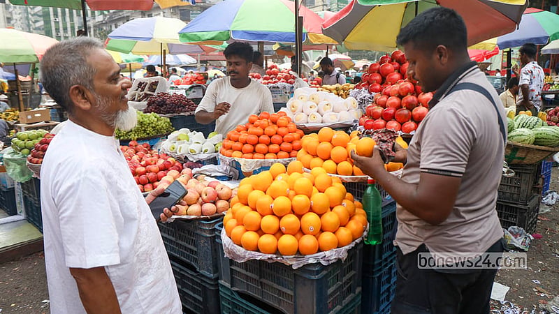 A shopper buys oranges from a retail shop at Dhaka’s Karwan Bazar. Photo: Shamsul Haque Ripon
