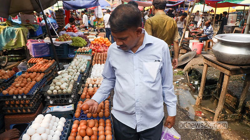 A customer checks eggs before buying them at Dhaka’s Karwan Bazar. Photo: Shamsul Haque Ripon