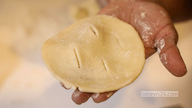 Three long cuts are made with a knife across each rolled-out piece before it goes into the oven. Photo: Shamsul Haque Ripon