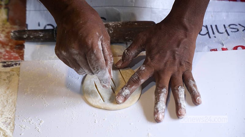 Three long cuts are made with a knife across each rolled-out piece before it goes into the oven. Photo: Shamsul Haque Ripon