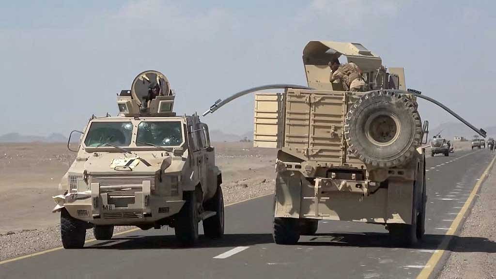 Yemeni government fighters shown driving vehicles over Houthi opponents