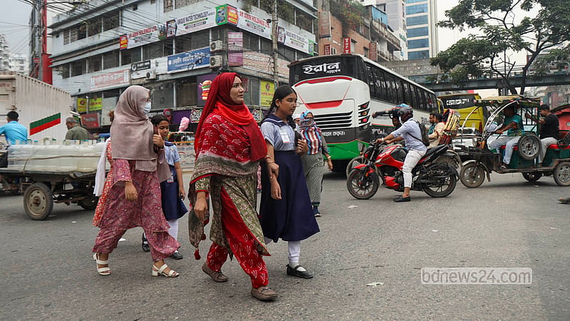 Parents cross the busy Malibagh intersection with school-going children despite a footbridge being available for safe passage. Photo: Shamsul Haque Ripon