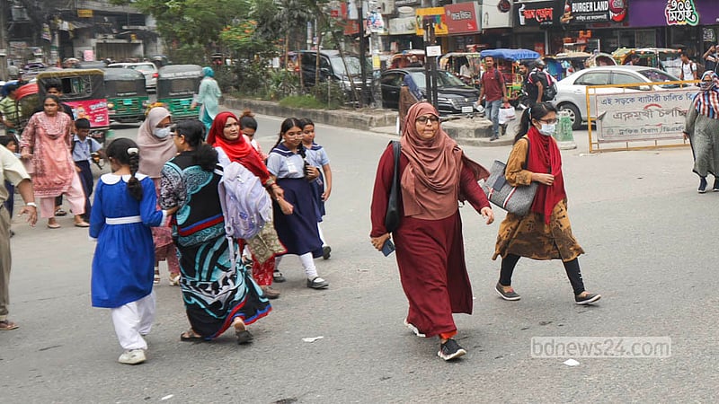 Parents cross the busy Malibagh intersection with school-going children despite a footbridge being available for safe passage. Photo: Shamsul Haque Ripon