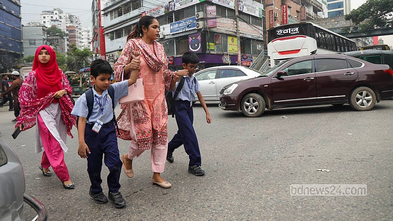 Parents cross the busy Malibagh intersection with school-going children despite a footbridge being available for safe passage. Photo: Shamsul Haque Ripon
