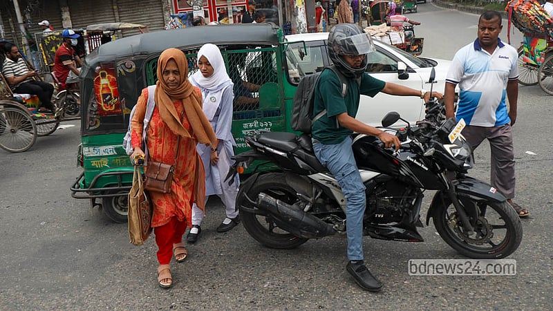 Parents cross the busy Malibagh intersection with school-going children despite a footbridge being available for safe passage. Photo: Shamsul Haque Ripon