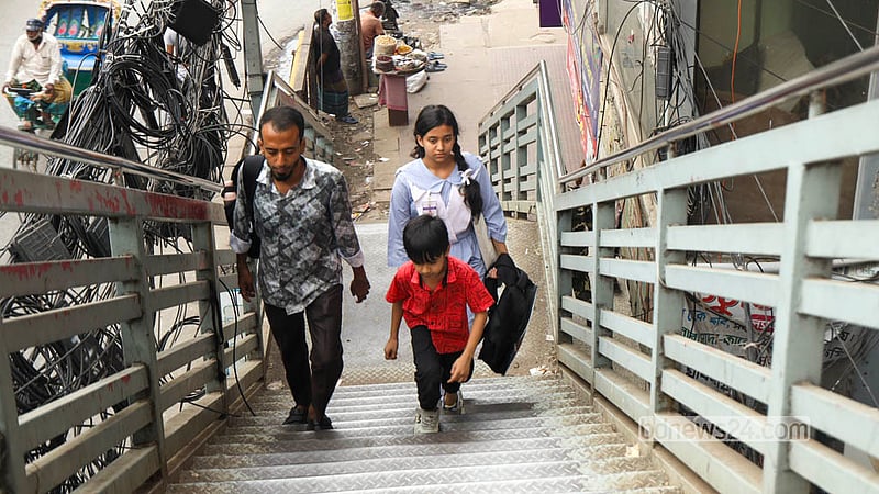 Parents use the footbridge to safely cross the busy Malibagh road with their children after school. Photo: Shamsul Haque Ripon