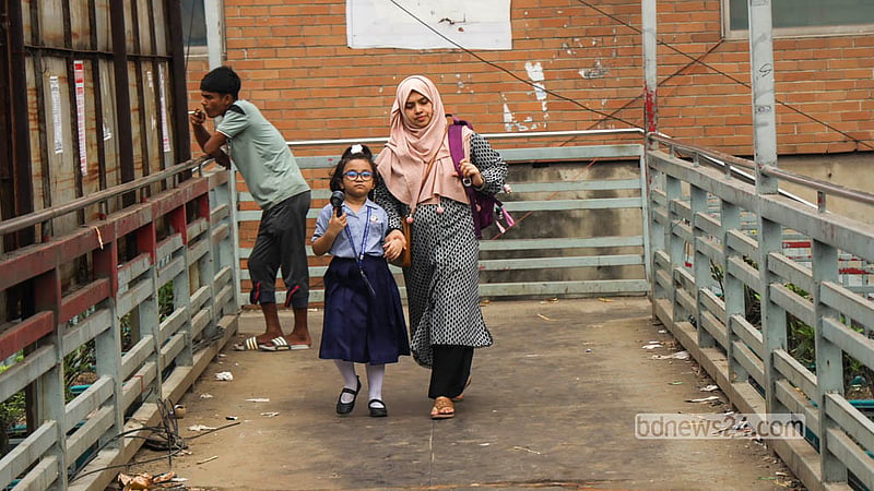 Parents use the footbridge to safely cross the busy Malibagh road with their children after school. Photo: Shamsul Haque Ripon