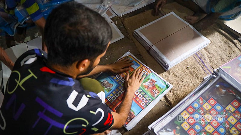 Employees apply pictures onto boards in a final step of Ludo board production at the Quader Ludo Factory in Chhoto Katra in Old Dhaka’s Chawkbazar. Photo: Shamsul Haque Ripon