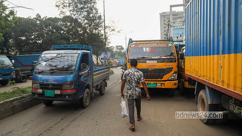 Trucks and covered vans parked carelessly across the road in Dhaka’s Tejgaon have narrowed the route for traffic. Photo: Shamsul Haque Ripon