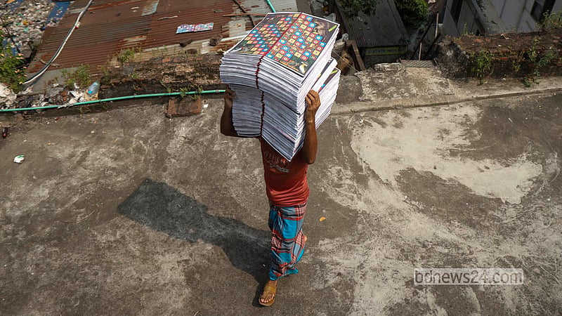A worker takes the Ludo boards made at a factory in Chhoto Katra in Old Dhaka’s Chawkbazar to dry on the roof in the sun. Photo: Shamsul Haque Ripon
