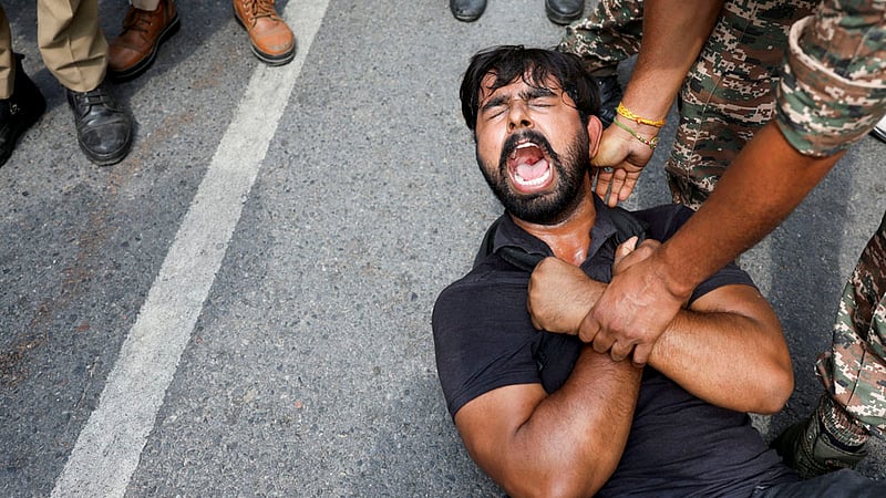 A protester is detained by security personnel during a protest by the Cockroach Janta Party (CJP) seeking the resignation of India's Chief Election Commissioner Gyanesh Kumar, near the protest site in New Delhi, India, October 11, 2026. Photo: Reuters