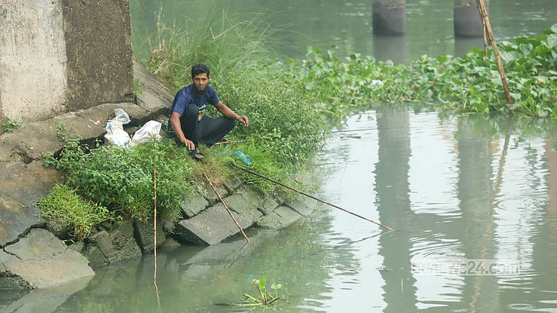 An amateur fisherman casts a line in Dhaka's Buriganga River in the hope of catching fish. Photo: Shamsul Haque Ripon