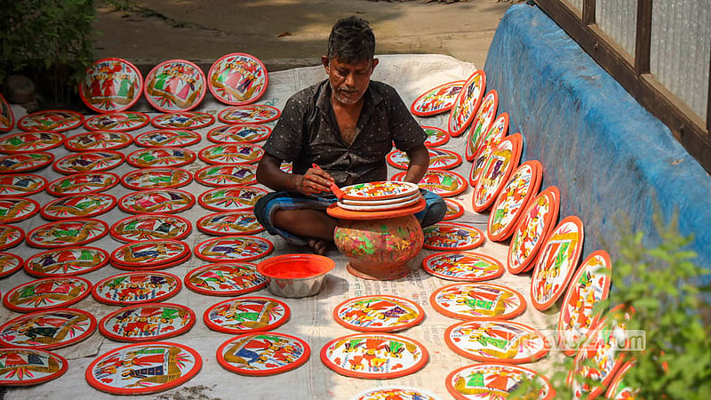 A potter paints clay discs left to dry in the sun in Sirajdikhan’s Palpara in Munshiganj.  Photo: Shamsul Haque Ripon