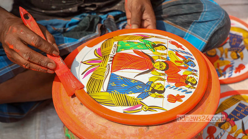 A potter paints clay discs left to dry in the sun in Sirajdikhan’s Palpara in Munshiganj.  Photo: Shamsul Haque Ripon
